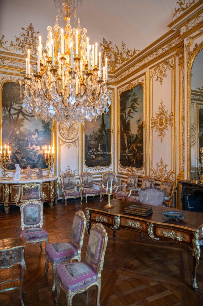 Une pièce intérieur du château de chantilly avec une beau lustre lumineux 