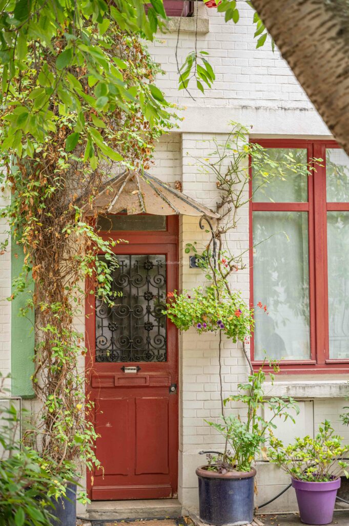 Ruelle de paris avec beaucoup de plantes zoom sur une porte