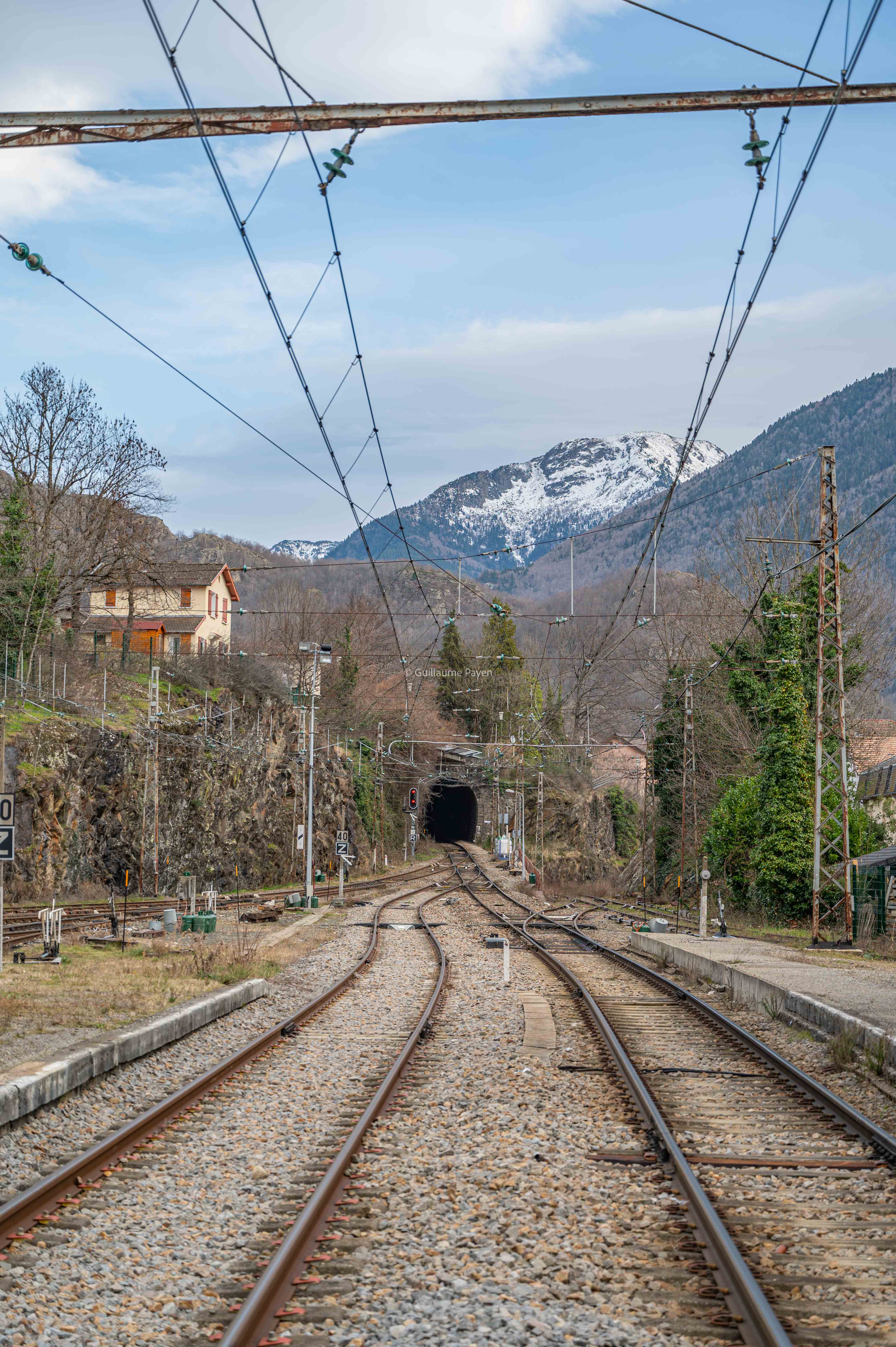 Les voies de train de la gare de Ax-les-Thermes, on voit la montagne au loin.