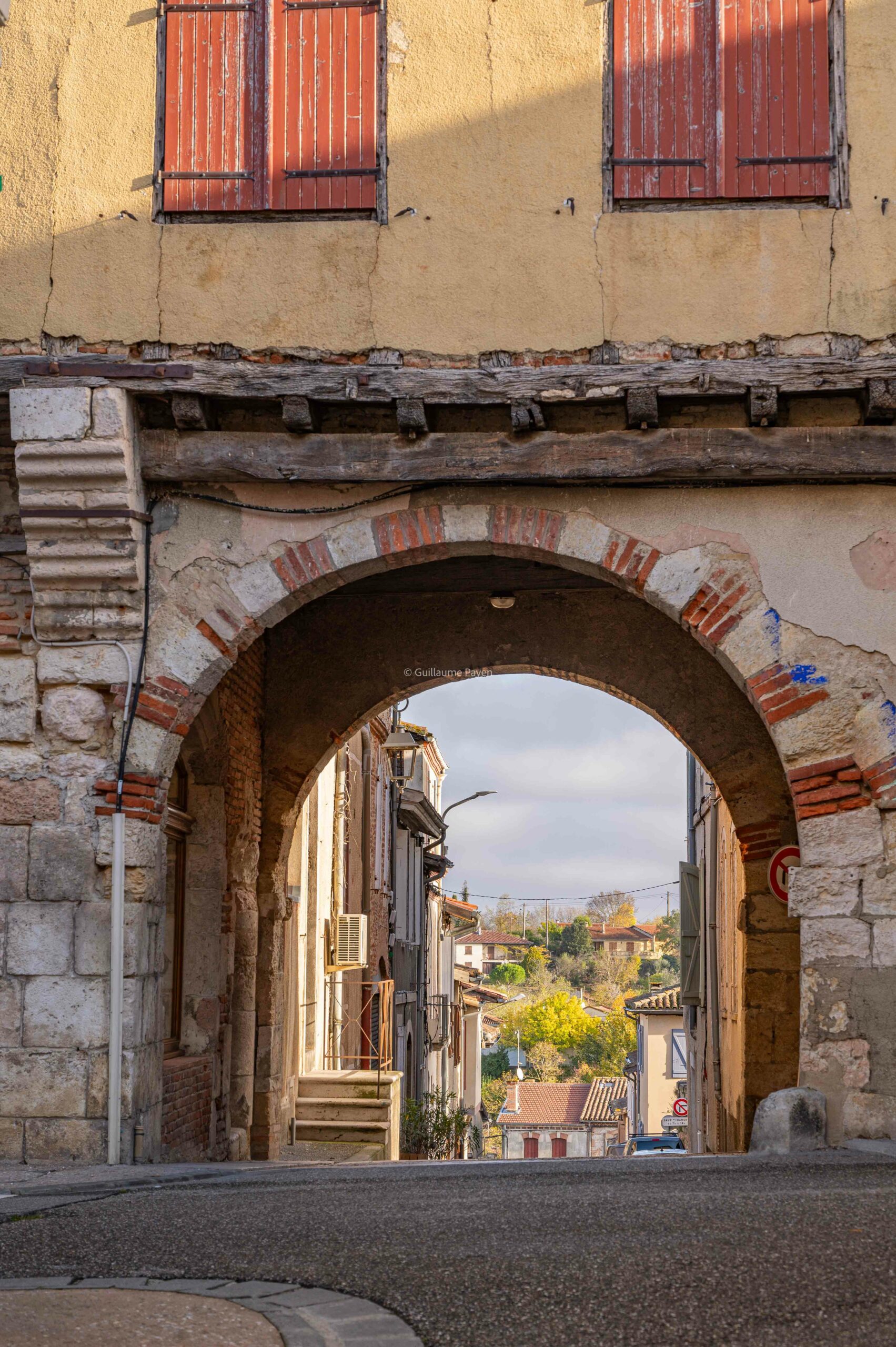 On voit une arche donnant sur une très belle ruelle de Gimont