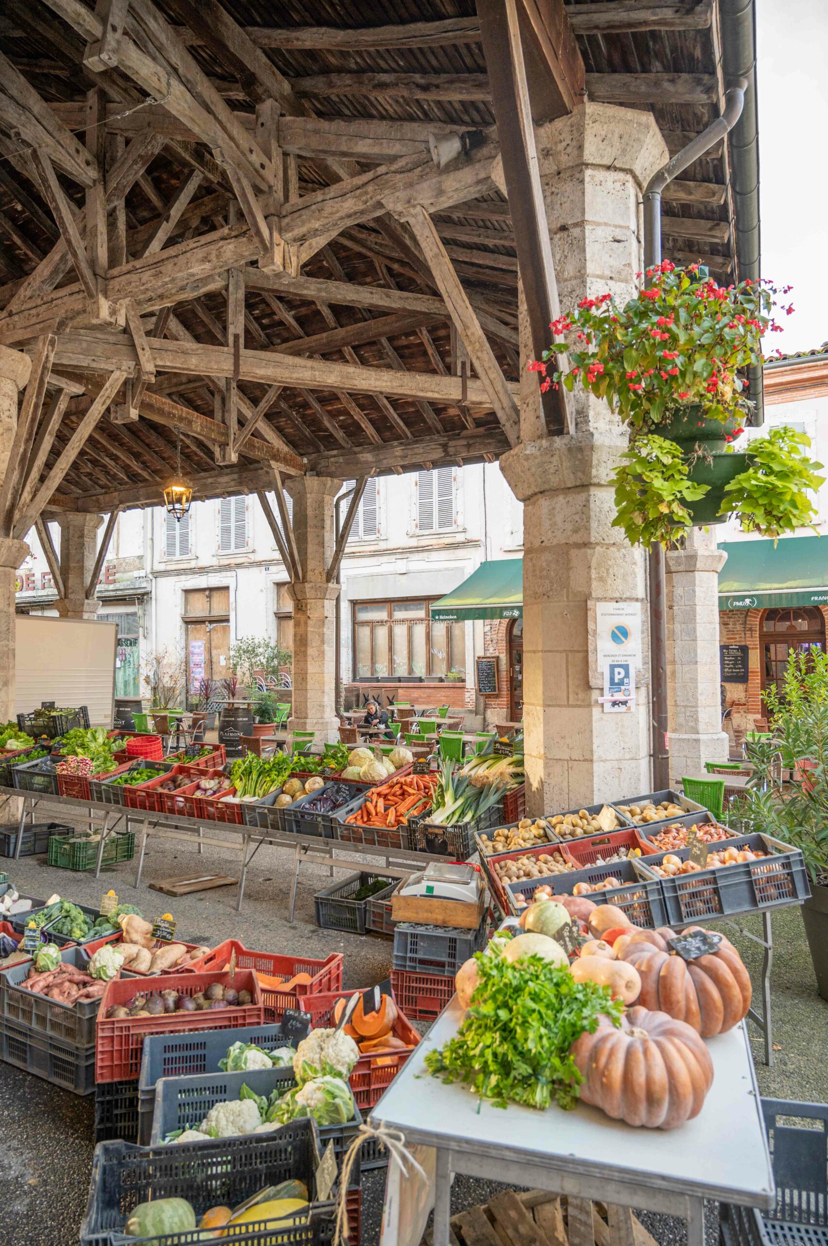 Le marché de Gimont avec des producteurs locaux et la halle centrale, on voit en premier plan une très belle mise en avant de produits avec diverses courges